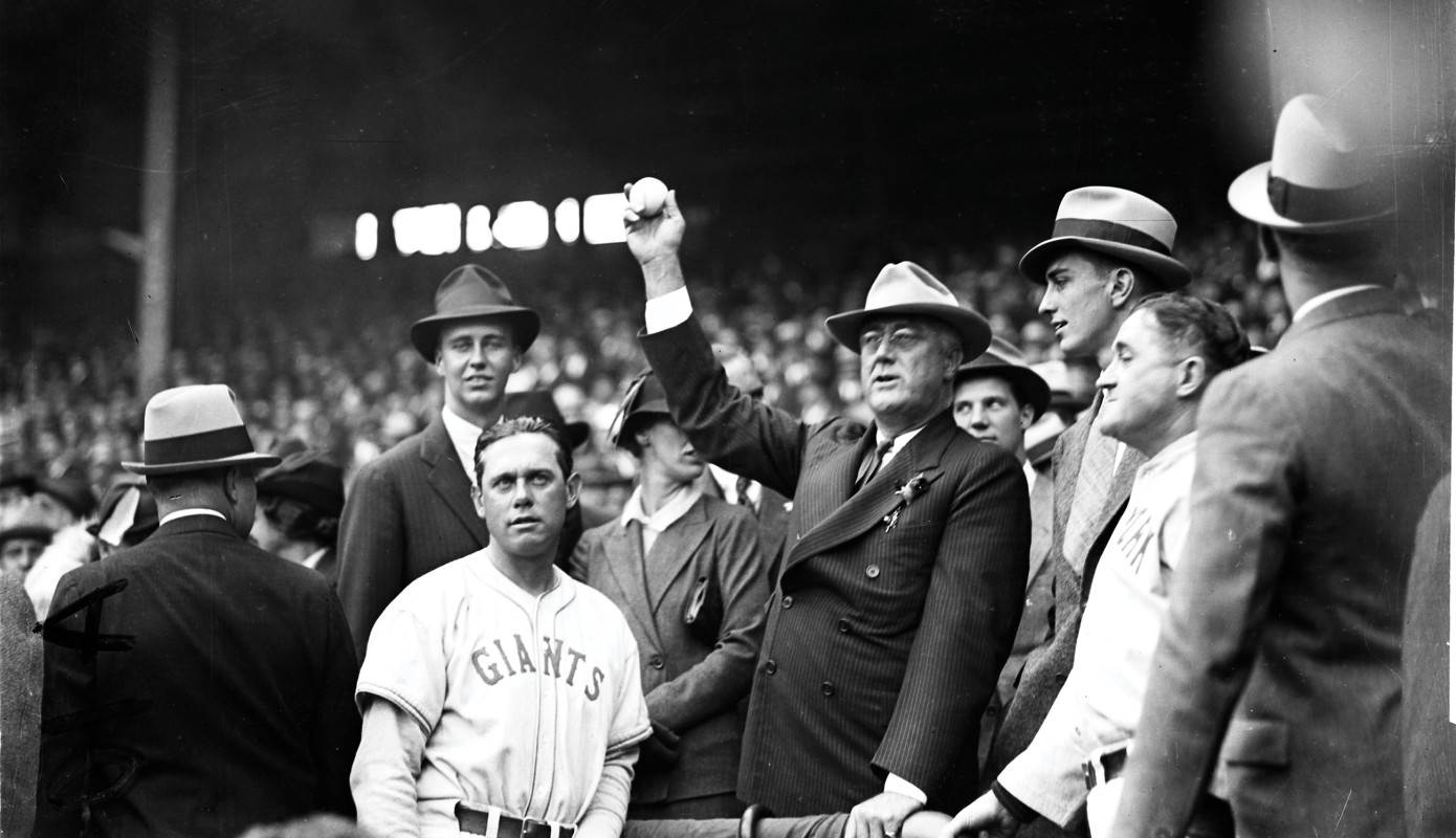President Franklin Roosevelt throwing out the first pitch at the second game of the 1936 World series, held at the Polo Grounds in New York. FDR would go on to urge the baseball leagues to keep playing during wartime.